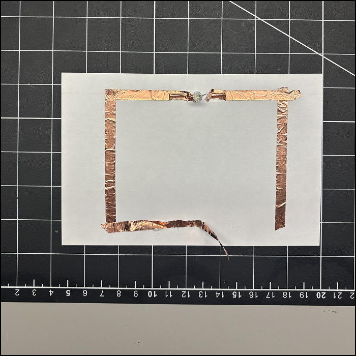 My first try using copper tape. It didn't work because the tape wasn't long enough for the battery's positive and negative sides to connect. Also, the tapes' direction aren't aligning with the LED.